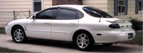 1997 Ford Taurus sedan, side view, white paint, aftermarket wheels