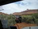 1986 Ford Bronco II - A brown 1986 Ford Bronco II navigates a dusty trail through a scenic canyon landscape, with another vehicle visible ahead.