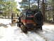 1986 Ford Bronco II - Ford Bronco II is stuck in snow with its driver's door open, spare tire visible on the back.
