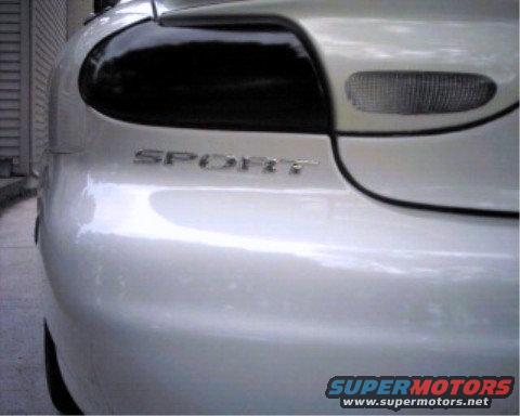 Rear quarter panel and taillight of a silver car with 'SPORT' badging