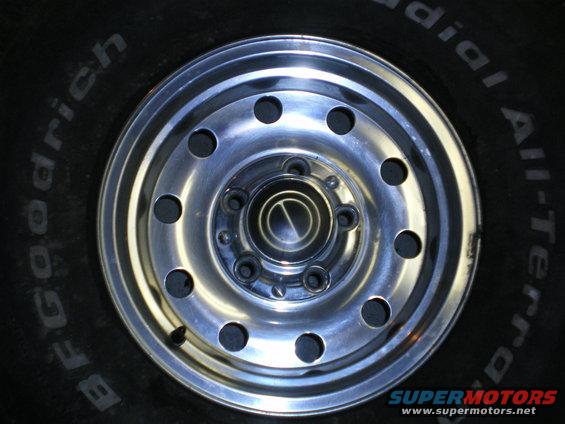 Close-up of a BFGoodrich All-Terrain tire with a chrome wheel showing lug nuts