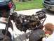 2010 Kawasaki BAYOU 220 - Disassembled three-wheeled ATV frame and parts are laid out on a driveway.