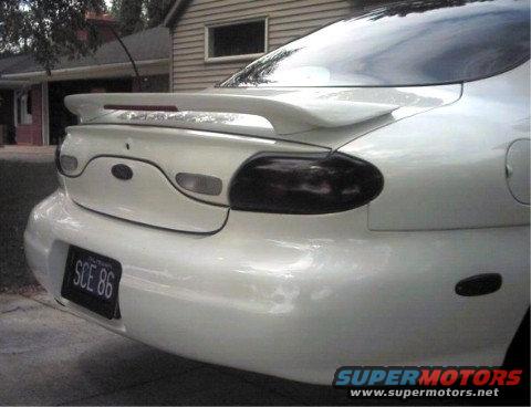 White 1997 Ford Taurus rear with spoiler and custom taillights. License plate reads SCE 86