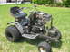 2010 Kawasaki BAYOU 220 - This modified riding mower has an exposed engine and battery, and appears to be undergoing repairs or customization.