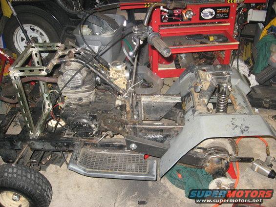 ATV chassis with engine, handlebars, and front fender removed, viewed from the side