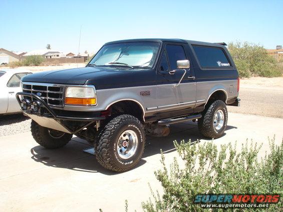 1994 Ford Bronco with aftermarket bumper and lift kit, parked outdoors