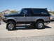 1994 Ford Bronco - This lifted 1994 Ford Bronco is parked on a concrete driveway under a clear blue sky.