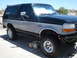 1994 Ford Bronco - This two-tone black and silver Ford Bronco is shown from the front three-quarter angle.