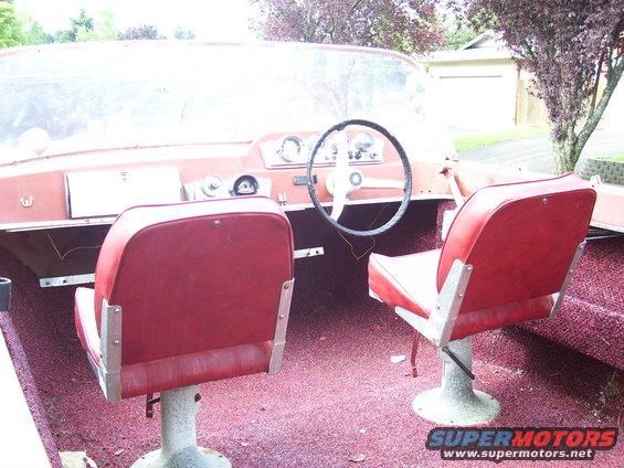 Red vinyl boat interior with two bucket seats and a steering wheel