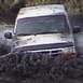 1993 Ford Bronco - A white van is submerged in thick mud, with only the top half visible.