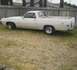 1971 Ford Ranchero - This Ford Ranchero is parked on a grassy area next to a wooden fence.