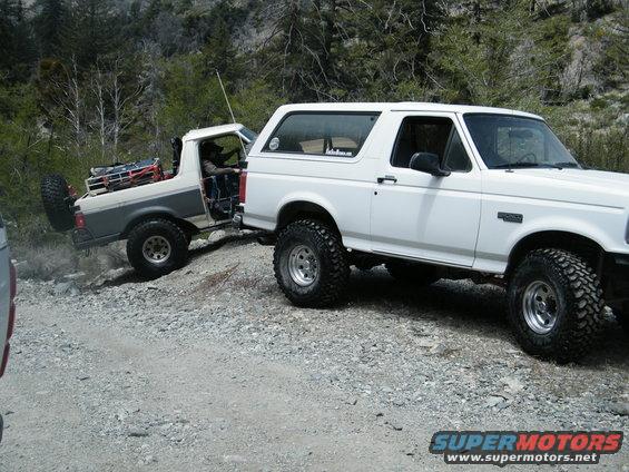 White 1992 Ford Bronco towing a gray and white Bronco