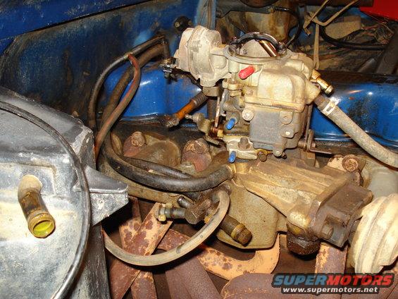 Carburetor and engine parts in blue engine bay