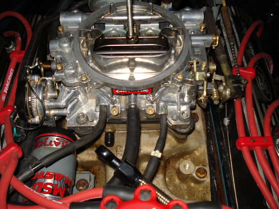 Holley carburetor with red MSD spark plug wires and a gray MSd ignition coil