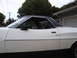 1973 Ford Ranchero - The side profile of a white 1973 Ford Ranchero pickup truck is visible, a black vinyl roof and chrome trim.