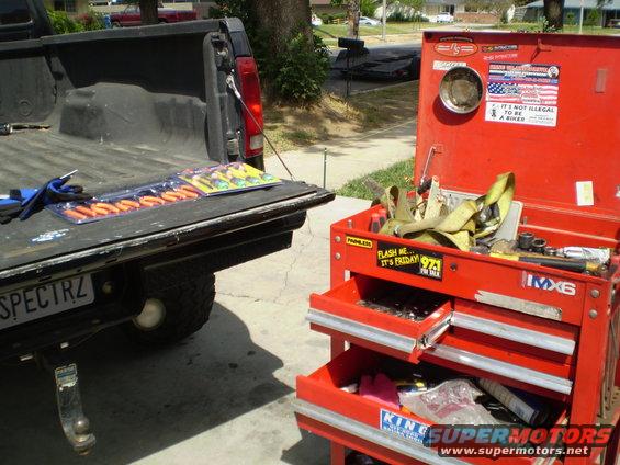 Tailgate of black pickup truck with tools and red toolbox