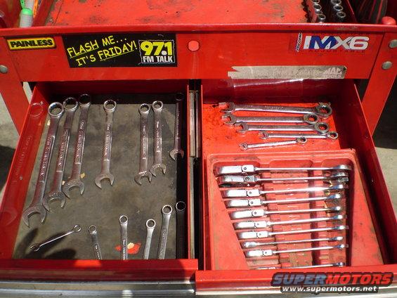 Red tool chest with open drawers filled with wrenches