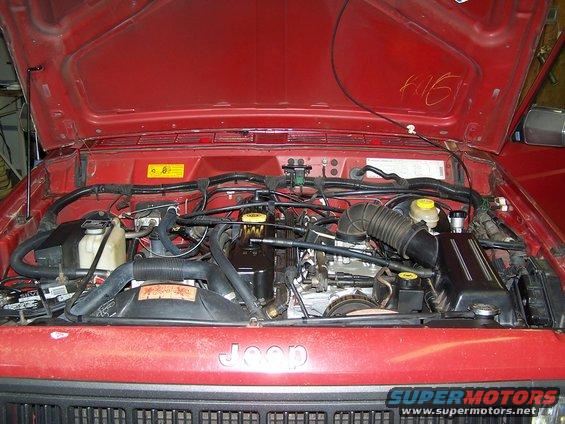 1991 Jeep Comanche engine bay with hood open. Jeep logo visible on grille