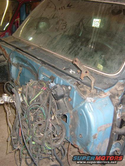 1985 Chevrolet C/K Pickup firewall with extensive engine bay wiring harness visible; another vehicle is partially seen to the left