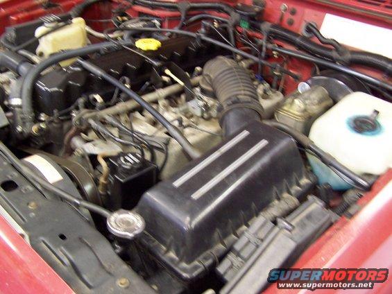 Jeep engine bay with air intake box and various hoses and fluid reservoirs