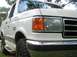 1989 Ford Bronco - This white Ford Bronco shows its 4x4 badging and front grille detail.