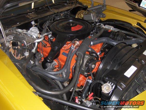 1971 Chevrolet Camaro engine bay with orange V8 engine, black air cleaner, and yellow fender