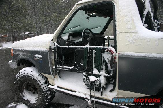 1991 Ford Bronco interior and side covered in snow