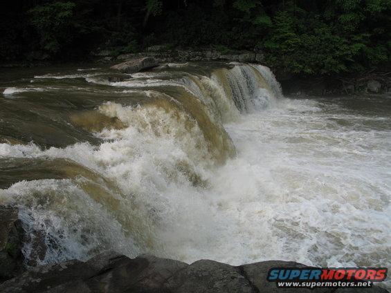 Waterfall cascading over rocks with trees in the background