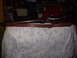 1966 Matchless G80 - A rifle with a brown leather strap is displayed on a tablecloth with a floral pattern.
