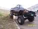 1994 Ford Bronco - This modified Toyota pickup truck is shown with its front tires on a curb and its rear tires on the ground.