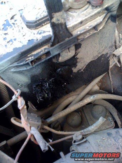 Close-up of corroded battery terminal and tangled wires in an engine bay