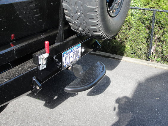 Rear bumper assembly with a diamond-plate step, spare tire mount, and New York license plate ADZ-2506