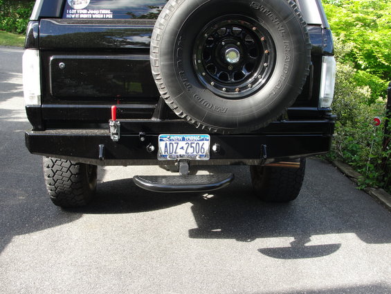 Black SUV rear bumper with spare tire, tow hitch, and New York license plate ADZ-2506