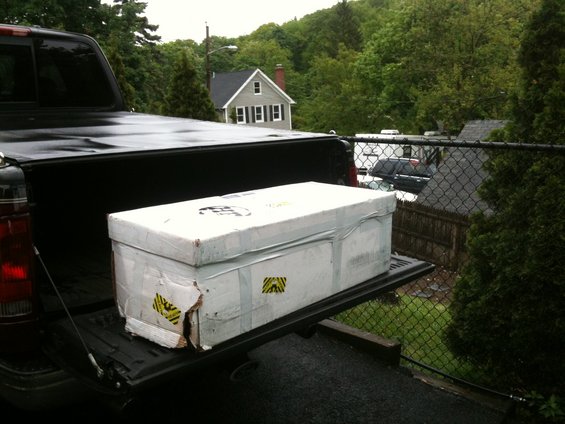 Large white box in the bed of a black pickup truck