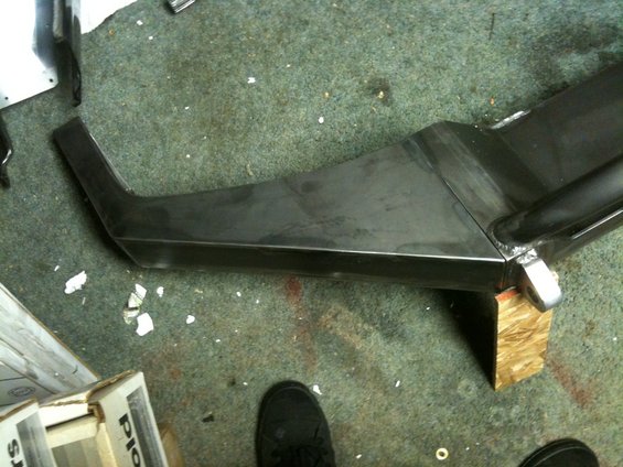 Custom metal bumper, unfinished, on a carpeted floor with wood blocks