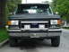 1988 Ford Bronco - Front view of a gray Ford Bronco with a chrome grille guard and auxiliary lights.