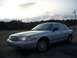 2003 Ford Crown Victoria - A silver 2003 Ford Crown Victoria sedan is parked outdoors under a cloudy sky.