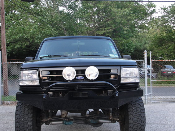 Front view of black 1995 Ford Bronco with custom bumper and dual spotlights