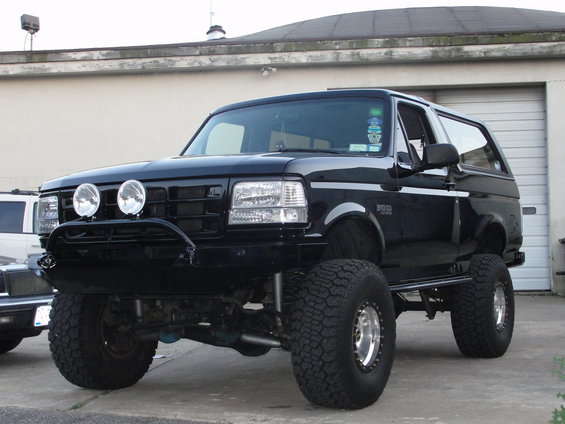 Black lifted Ford Bronco with aftermarket bumper and lights