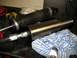 1996 Ford Bronco - Close-up of two shock absorbers and a hydraulic hose on a workbench.