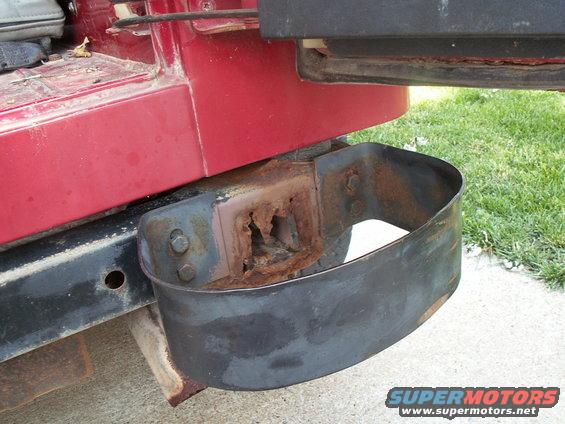 Red Jeep YJ rear bumper mount with significant rust, showing a curved black metal guard