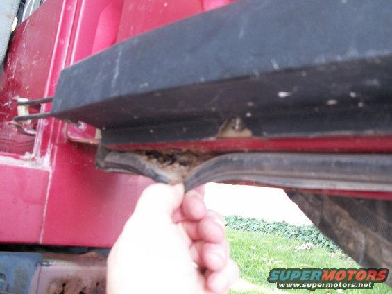 Red vehicle door seal being pulled away from the body