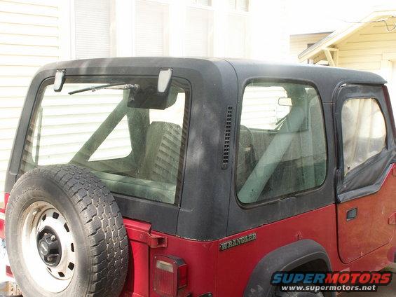 1988 Jeep YJ rear quarter view, red body, black hardtop, spare tire mounted on rear door