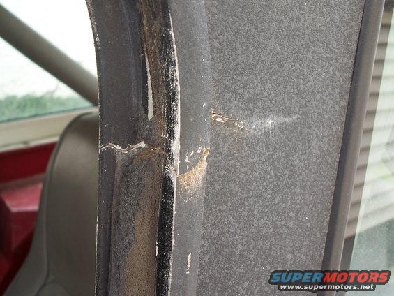Close-up of worn interior door frame with peeling paint and rust