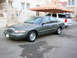 2001 Mercury Grand Marquis - A 2001 Mercury Grand Marquis is parked in front of a white SUV under a shaded canopy.