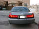2001 Mercury Grand Marquis - Rear view of a 2001 Mercury Grand Marquis, with a green VW Beetle visible in the background.