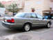 2001 Mercury Grand Marquis - A gray sedan is parked on a street with buildings and other vehicles visible in the background.