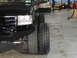 1995 Ford Bronco - Comparison of two different tire sizes on a black SUV in a garage setting.