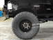 1995 Ford Bronco - Close-up of a black 1995 Ford Bronco's front tire and fender, with the "BRONCO XLT" badge visible.