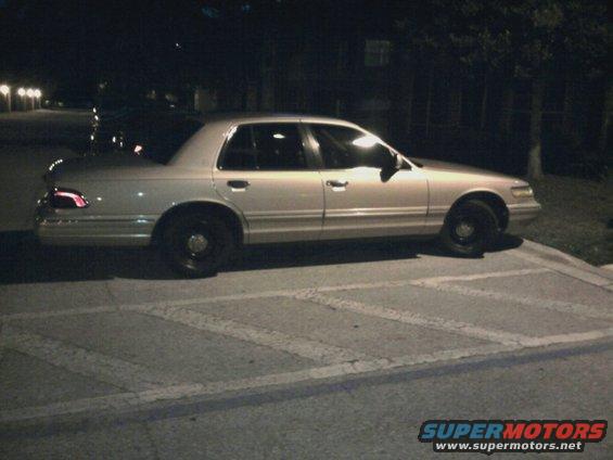Silver 1996 Mercury Grand Marquis sedan, side view at night